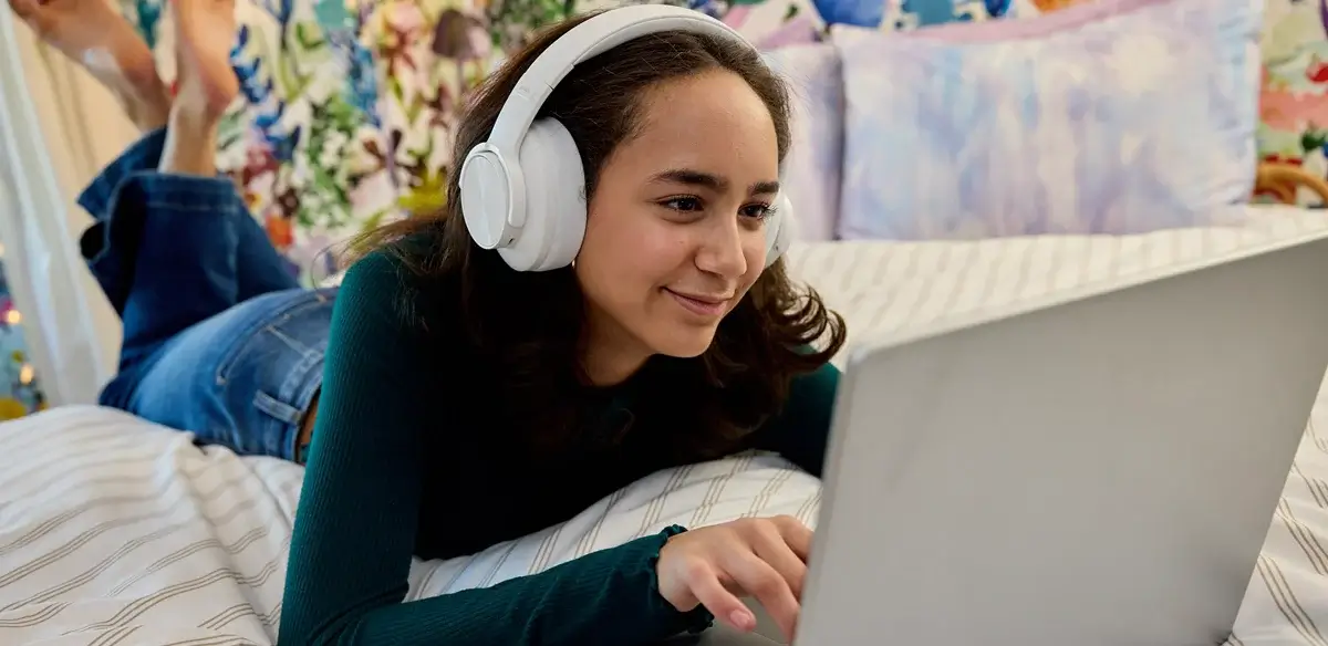 Student wearing a white pair of headphones